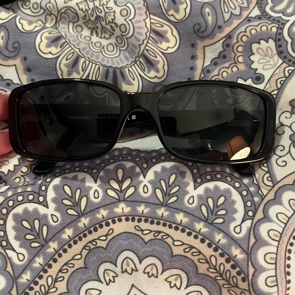 Black Chanel sunglasses with white double c logo and flower.